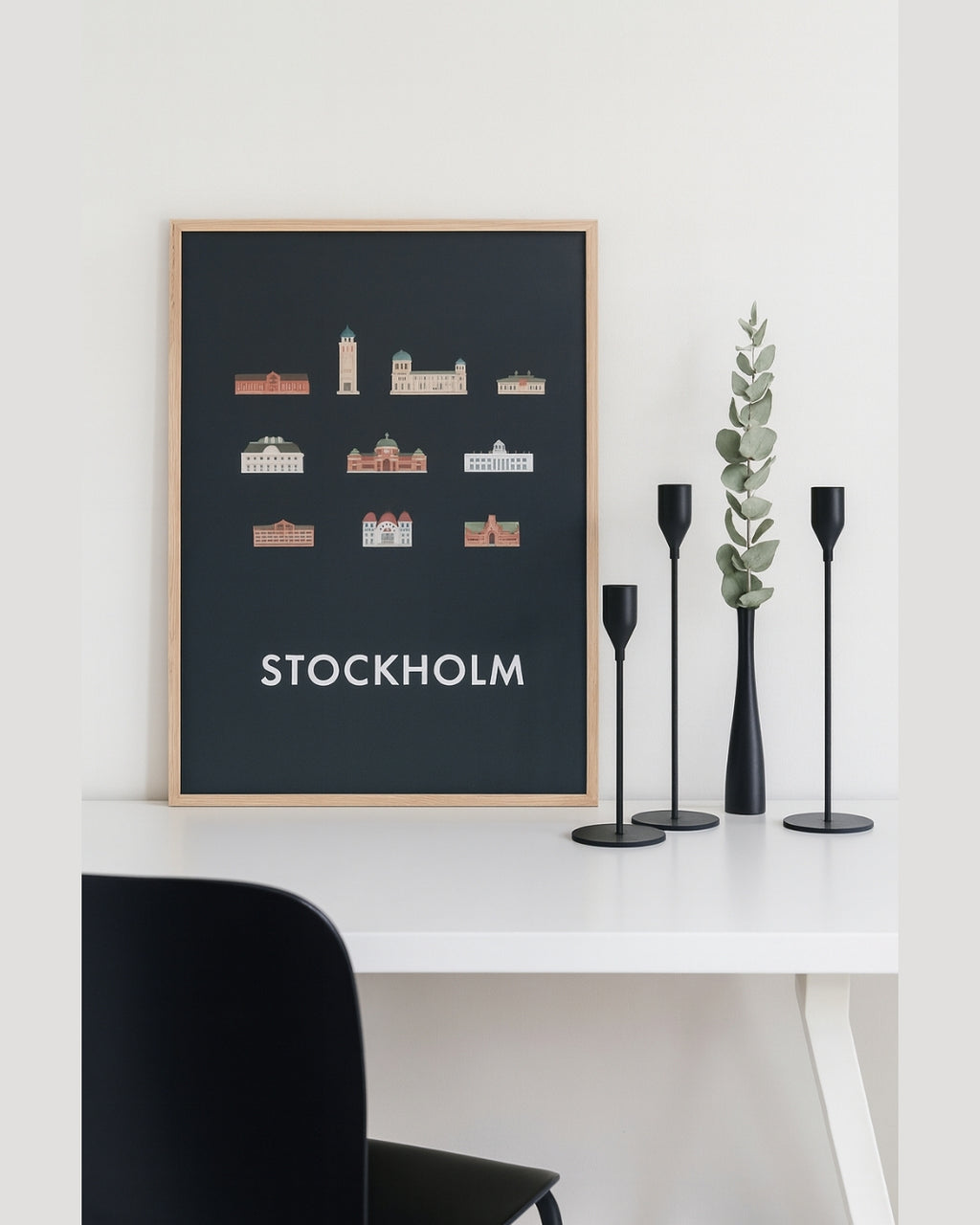 Set om tre mattsvarta ljusstakar på skrivbord framför tavla – modern skandinavisk stil